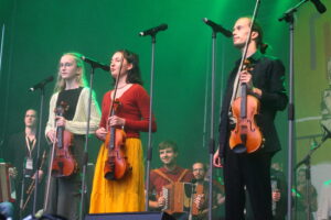 Zwei junge Frauen und ein junger Mann singen.