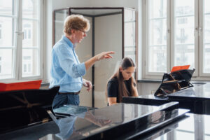 Mädchen mit Lehrer beim Klavierunterricht