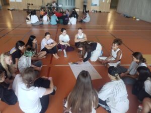 Gruppenarbeit in Turnhalle; Jugendliche sitzen im Kreis